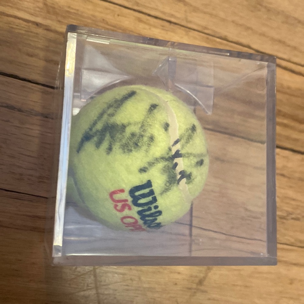 Wilson 1 US Open tennis ball signed by various players, including Andre Agassi.